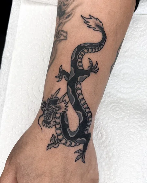 Black and grey dragon tattoo following the forearm, by Brodie Bailey